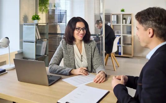 AML Compliance in Spain guide banner showing a compliance officer consulting with a client at an office desk