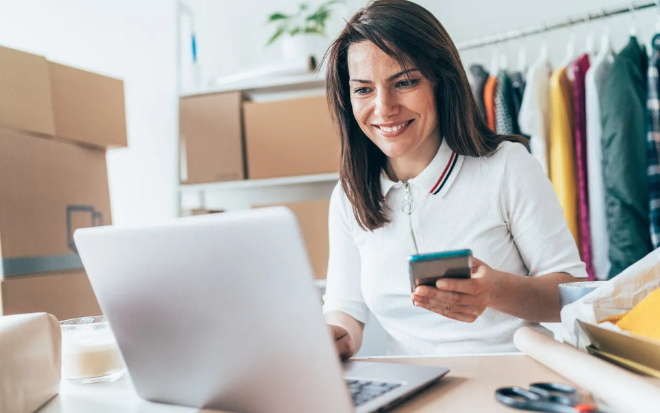 Digital Transformation for SMEs in Spain banner showing a smiling businesswoman using a smartphone and laptop in a workspace