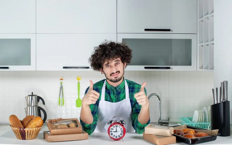 Course banner for "Fitness to Work: When Food Handlers Must Stay Off (48-Hour Rule)," featuring a male food handler in a white apron giving two thumbs up behind a kitchen counter with a red alarm clock, fresh bread, and packaged pastries.