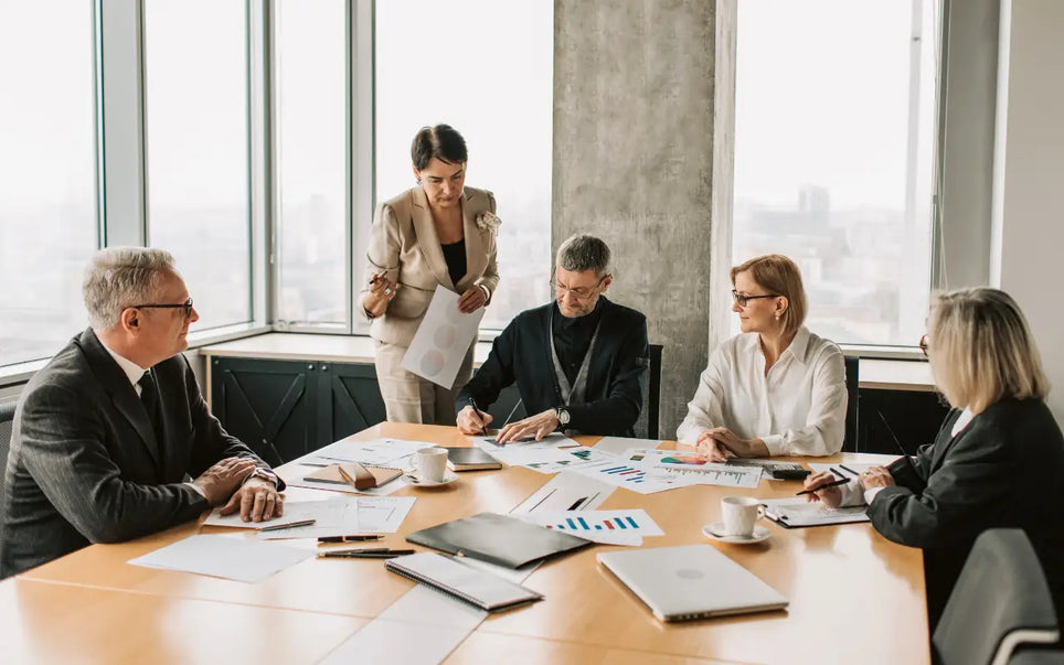 Corporate board reviewing compliance documents and financial reports to structure regulatory risk management for a business in Spain.