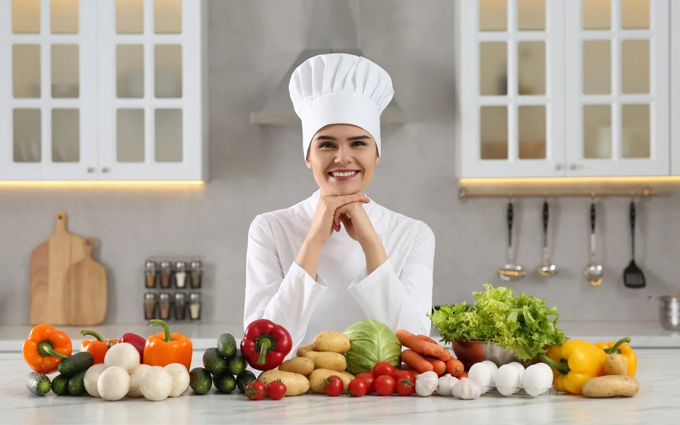 Course banner for "Level 1 vs Level 2 Food Hygiene: Which Do Food Handlers Need?", featuring a smiling female chef in a white uniform and chef's hat standing behind a kitchen counter filled with fresh vegetables.