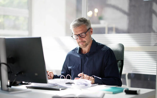 Minimum Wage Spain 2026 guide banner showing an accountant reviewing payroll documents at an office desk