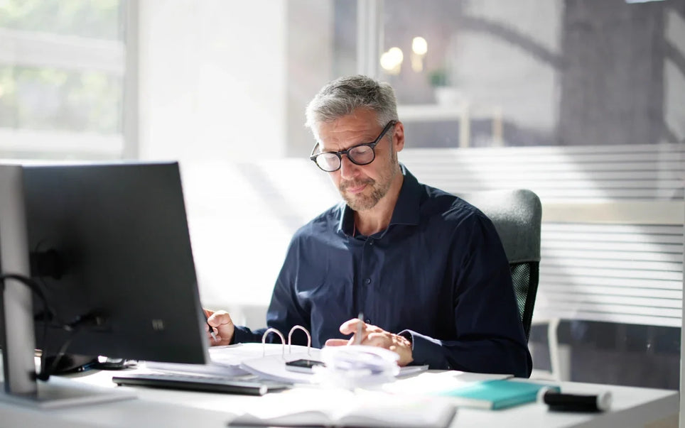 Minimum Wage Spain 2026 guide banner showing an accountant reviewing payroll documents at an office desk