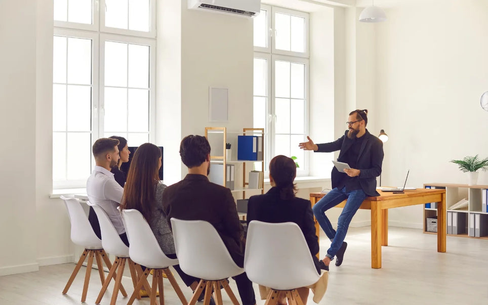 Course banner for "Scrum Leadership in Agile Project Management: Roles, Responsibilities, and Best Practices," featuring a male Scrum Master or Agile coach holding a tablet and leading a corporate training workshop for a team in a bright office.