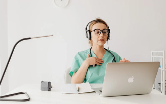Telemedicine compliance in Spain guide banner showing a female medical professional in scrubs and a headset during a video consultation