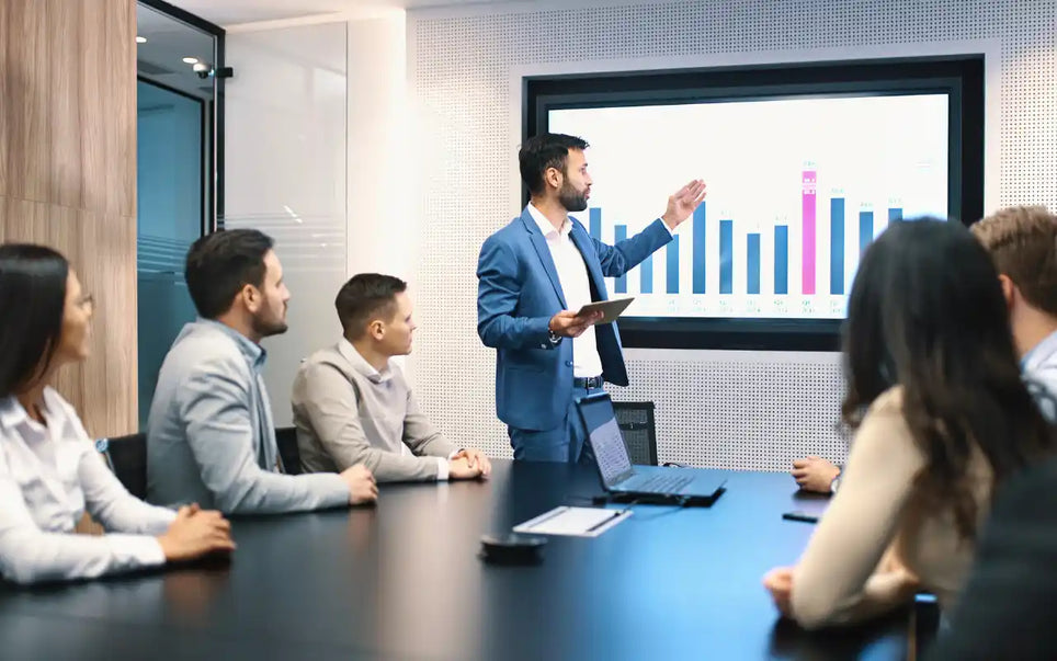 Corporate leader presenting digital growth analytics and transformation strategies to a team in a conference room.