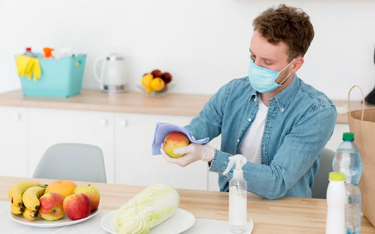 Person washing fresh red and green apples under running water in a kitchen sink.
